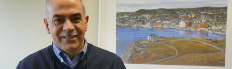 Dr. Gai sits in LMP Medical Director, Dr. Chetty’s office, with a painting of St. John’s, Newfoundland featured in the background.